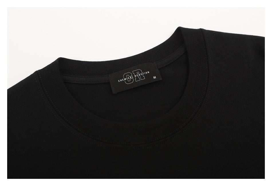 Close-up of the black T-shirt’s crew neckline and sewn brand label.