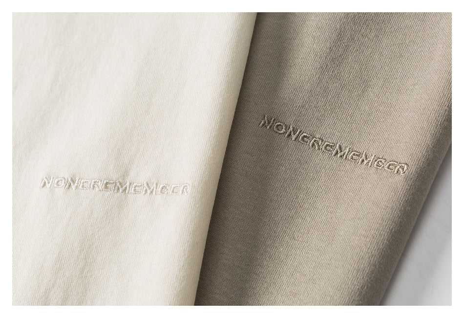 Close-up of cream and taupe fabric panels with tonal embroidered lettering.