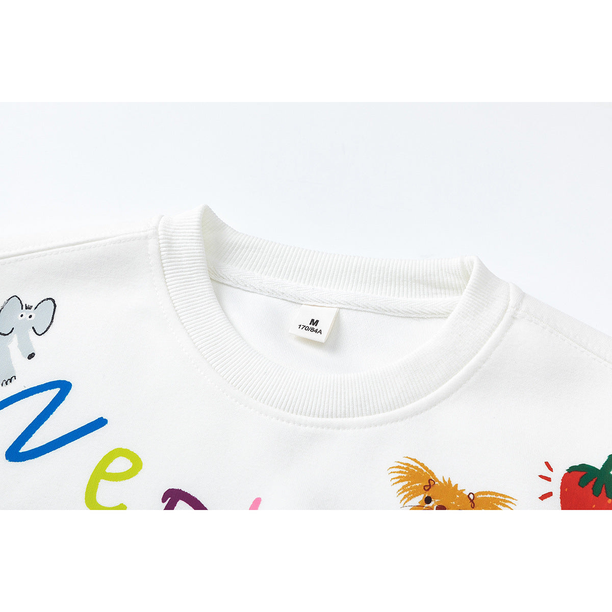 Close-up of a white sweatshirt's ribbed crew neck, size tag, and partial colorful cartoon print.