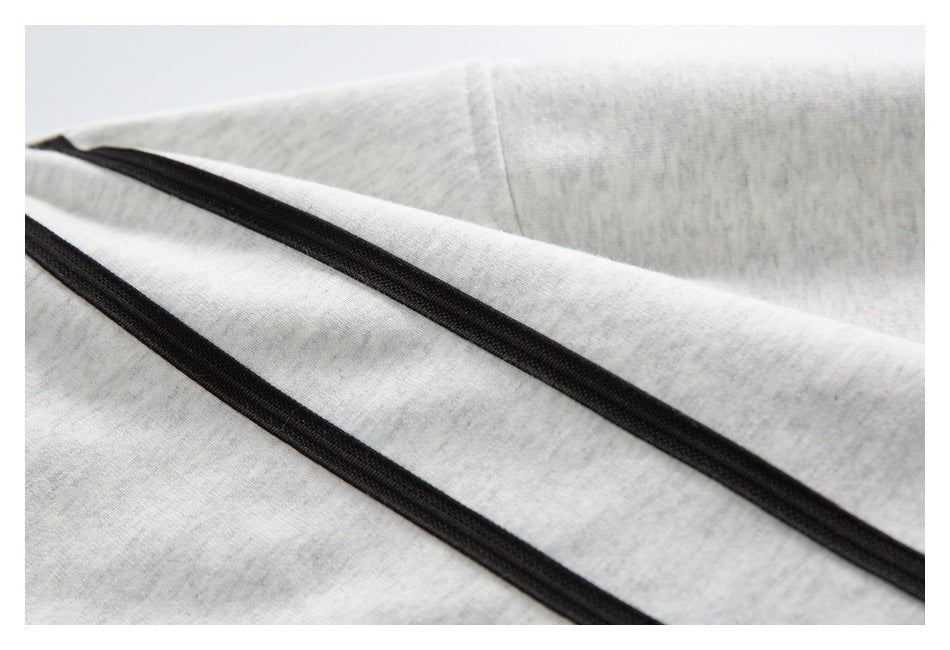 Close-up of two black trim lines across light gray heathered fabric.
