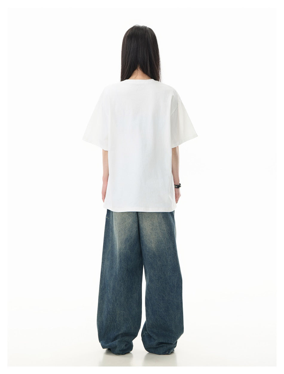 Back view of a model wearing a plain white oversized T-shirt and wide-leg blue jeans.