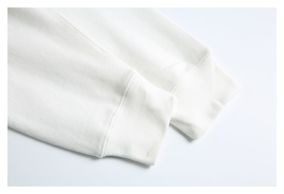 Close-up of the white hoodie’s ribbed sleeve cuffs and stitched seams.