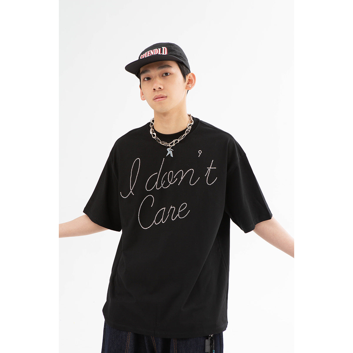 Close view of a model wearing a black oversized T-shirt with white cursive lettering.