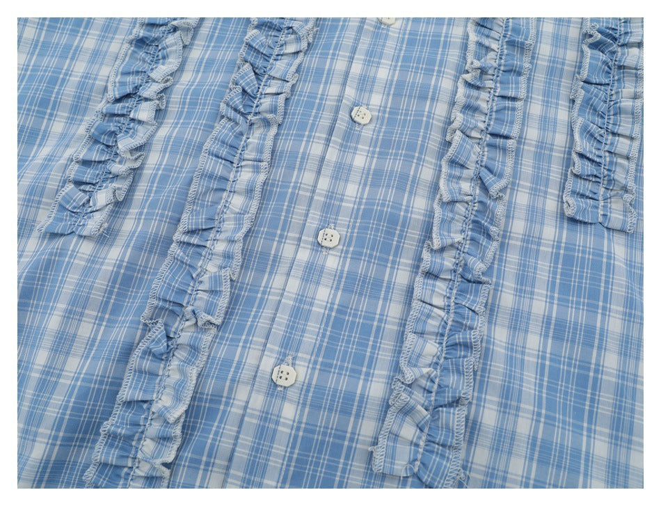 Blue-and-white plaid shirt front detail with white buttons and long ruffled trim.