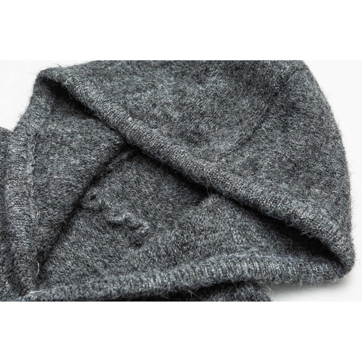 Close-up of a charcoal gray knit garment showing its fuzzy texture and folded edge.