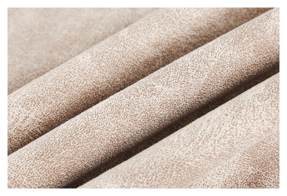 Close-up showing the fine mottled texture of pale beige fabric in soft folds.
