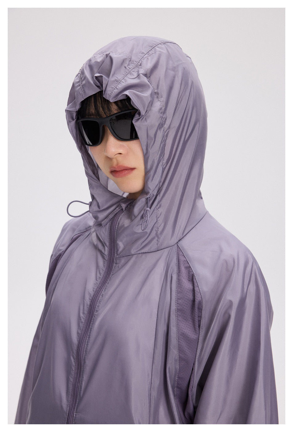 Close-up of the lavender jacket's adjustable hood, drawcords, zipper, and contrast mesh panel.