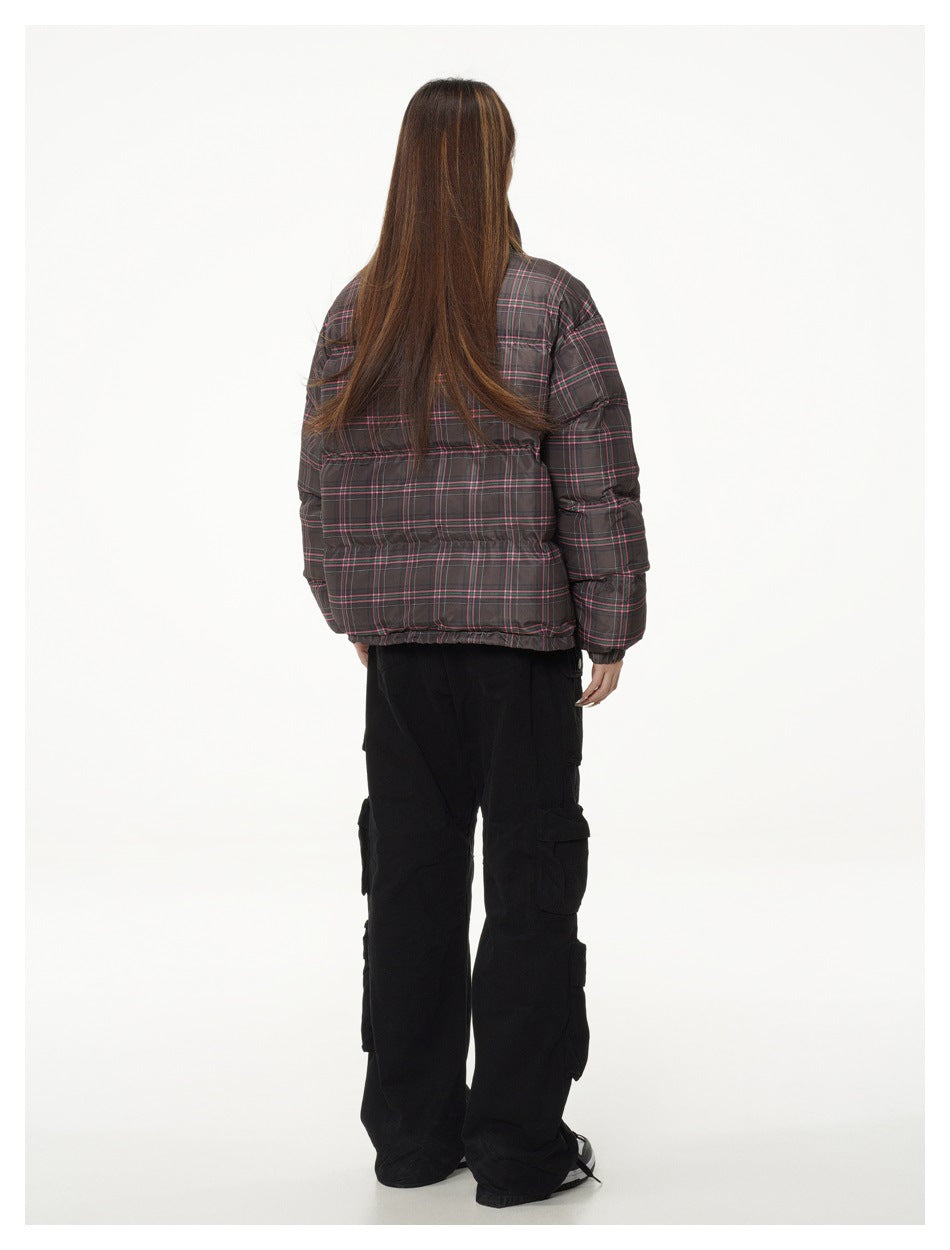 Rear view of a model wearing a dark gray plaid puffer jacket with pink lines and black cargo pants.
