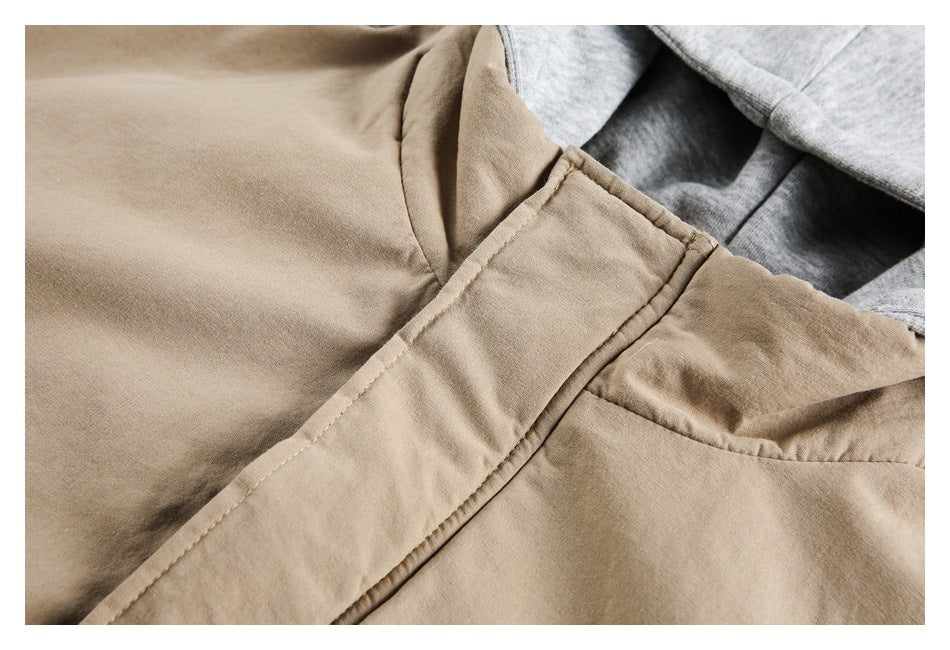 Close-up of the tan jacket's front placket, collar seam, and light gray hood lining.