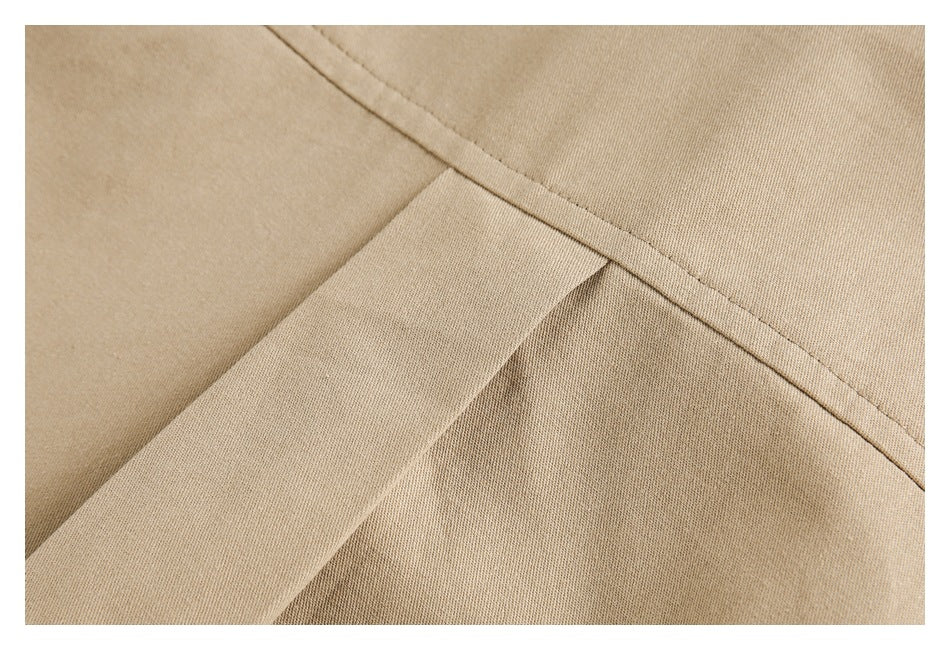 Close-up of beige fabric with a diagonal stitched seam and overlapping panel.