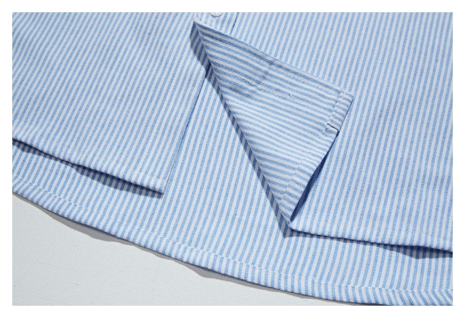 Close-up of the pointed collar and front placket of a blue-and-white striped shirt.