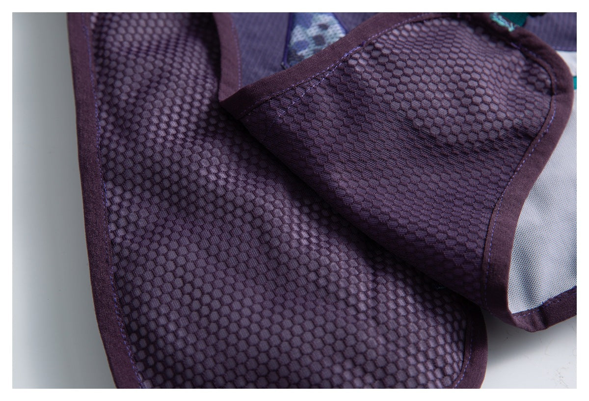Close-up of dark purple textured fabric and bound seams, with a folded panel revealing a light gray inset.