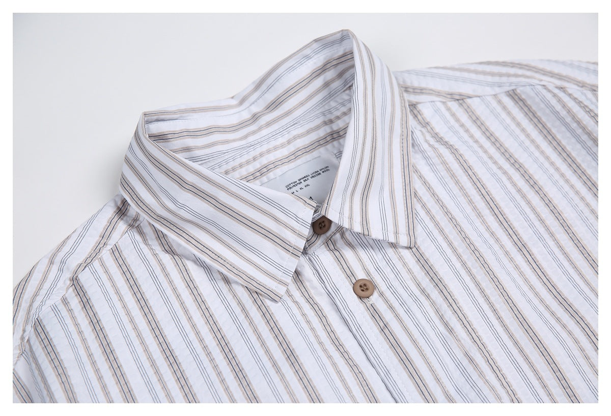 Close view of the striped shirt's pointed collar and upper button placket; a small English garment label is visible inside.