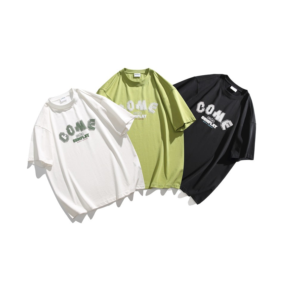 Three oversized graphic T-shirts arranged together in white, lime green, and black.