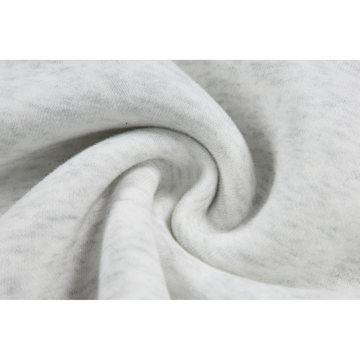 Extreme close-up of light gray mottled fabric gathered into soft folds.