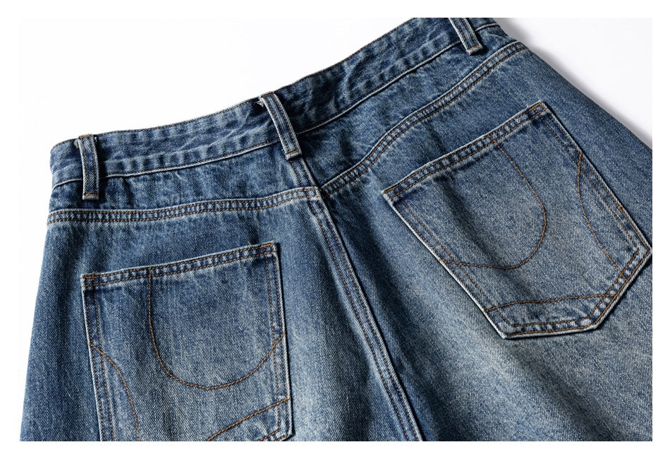 Close-up of the back of blue jeans, showing the waistband, belt loops, and two stitched pockets.