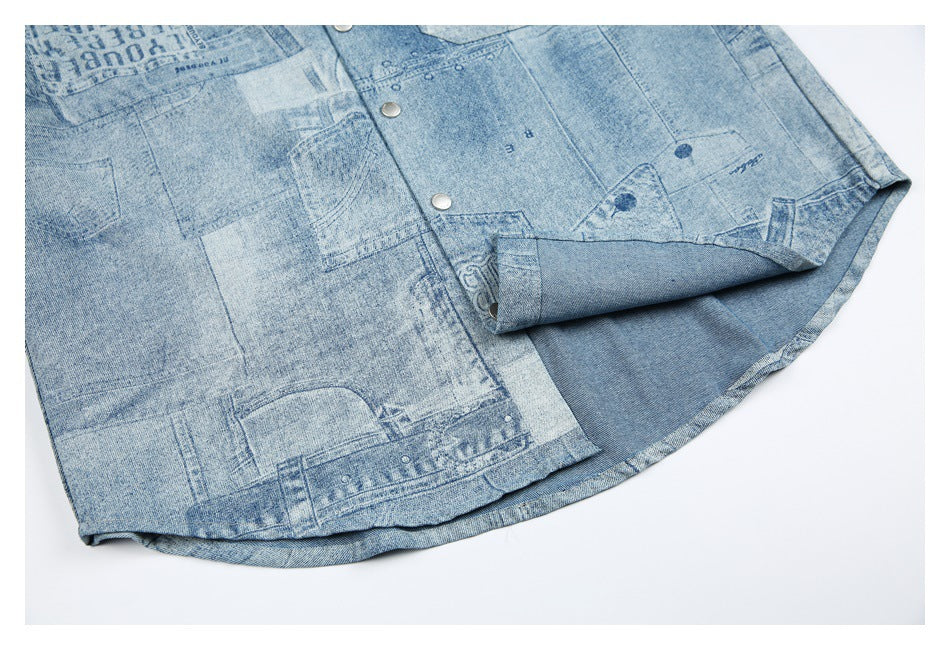 Partial view of a light blue denim garment with snap buttons, patchwork-style graphics, and a folded hem.