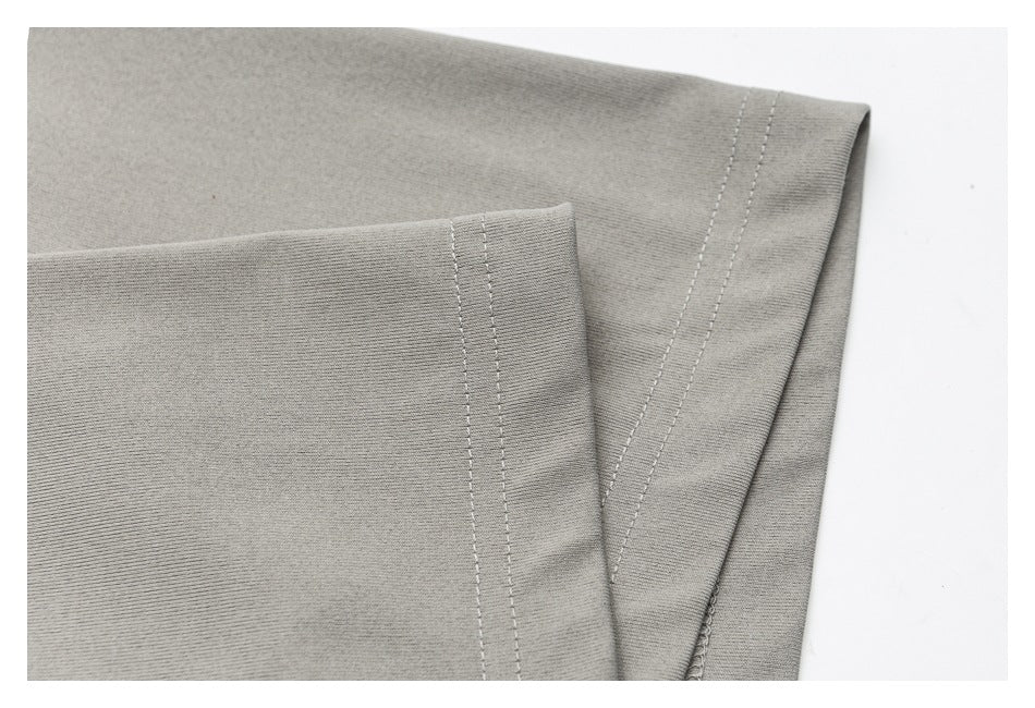 Close-up of a gray shirt edge showing its folded hem and parallel rows of stitching.