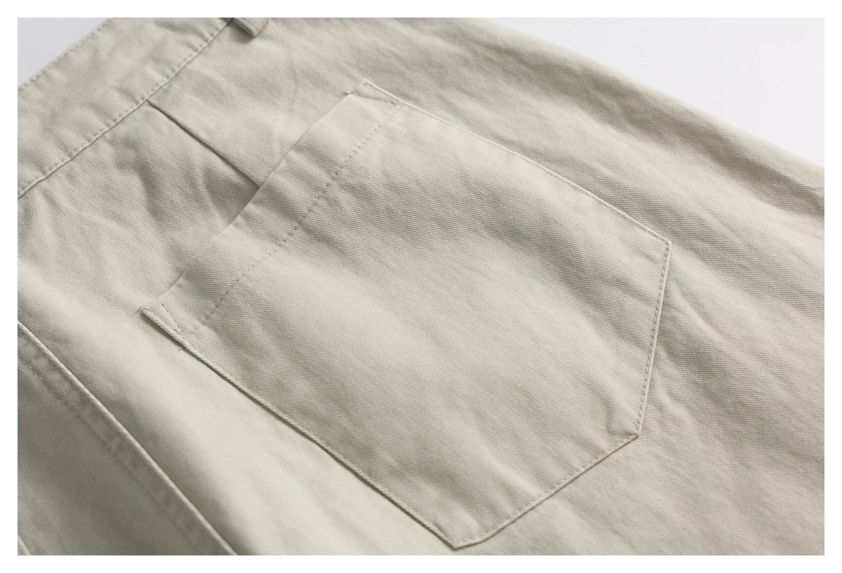 Close-up of a large angular patch pocket on light beige trousers.