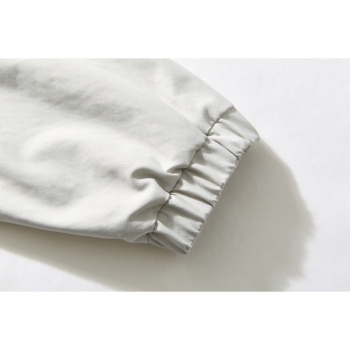 Close-up of an off-white jacket sleeve ending in a gathered elastic cuff.