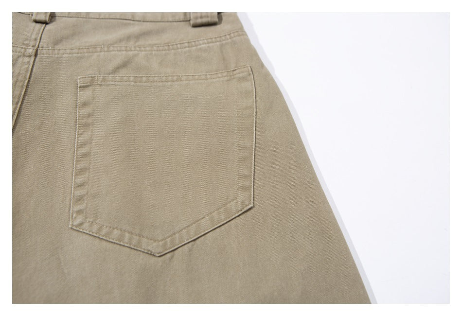 Close-up of the back of khaki trousers, featuring a single stitched patch pocket.