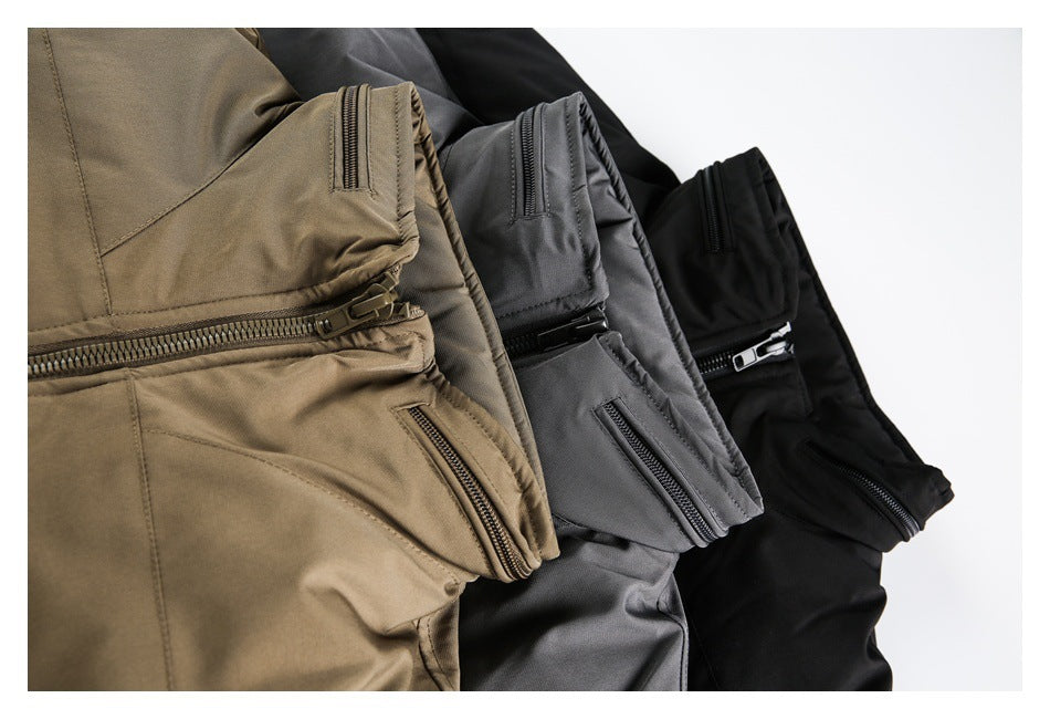 Close-up of folded taupe, charcoal gray, and black jackets showing zippered details.
