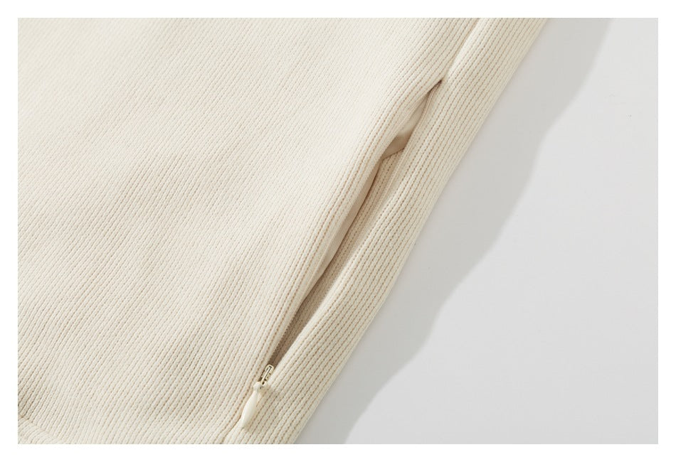 Close-up of a concealed side zipper on the ivory ribbed garment.