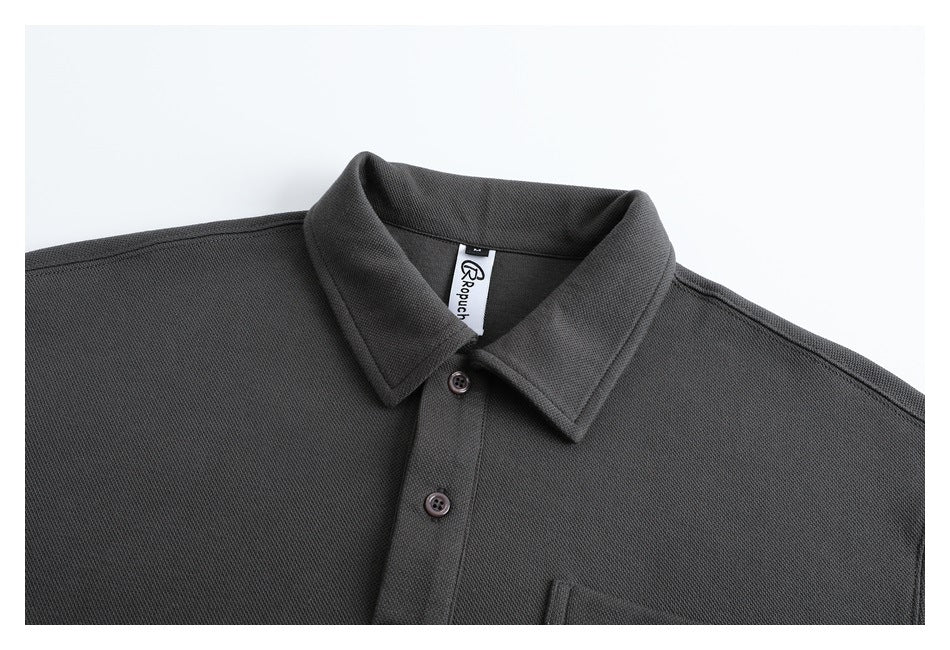 Close-up of the charcoal pullover's collar, two-button placket, textured surface, and sewn neck label.
