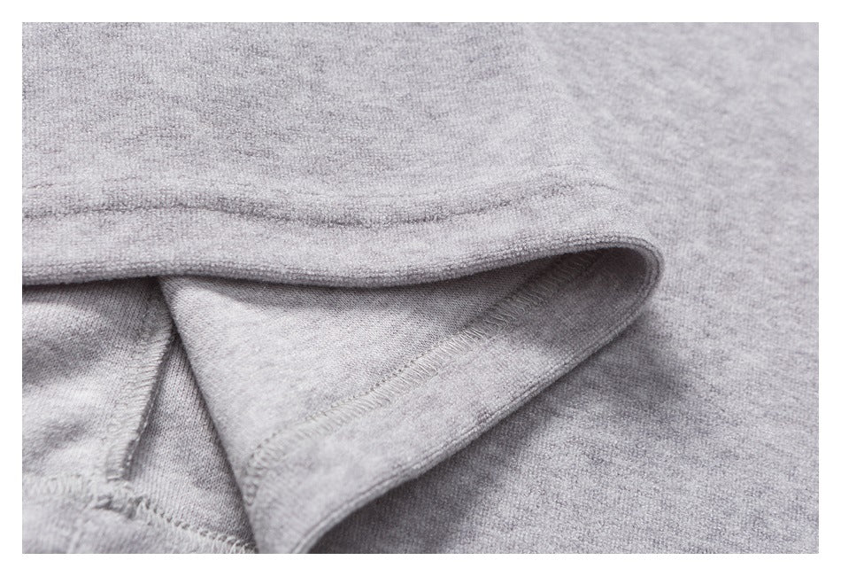 Close-up of a folded edge on heather-gray fabric, showing the seam stitching.