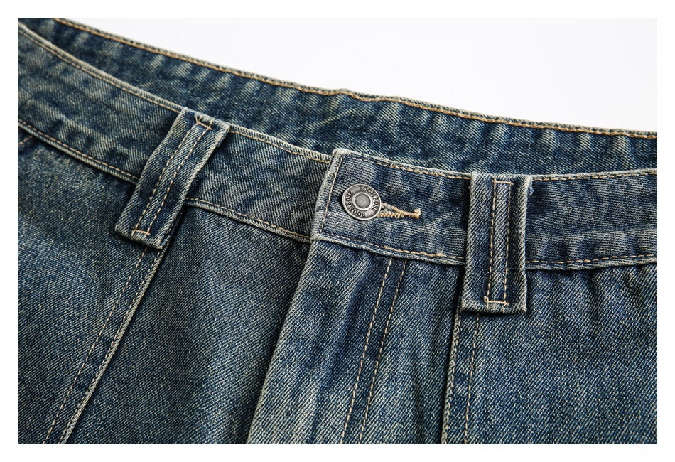 Close-up of the denim waistband with belt loops, button, and reinforced stitching.