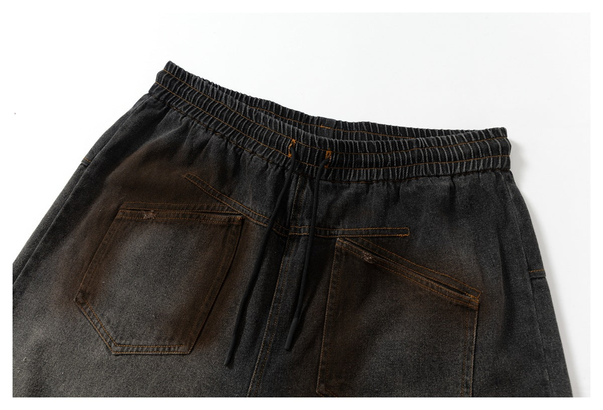 Close-up rear view of charcoal washed shorts showing an elastic waistband, black drawstrings, and two patch pockets.