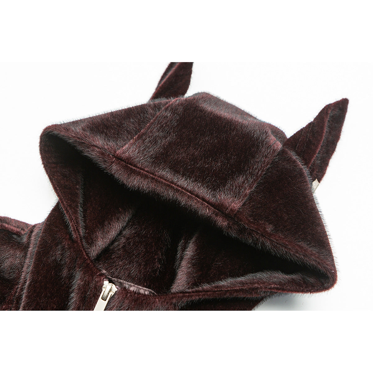 Close-up of a dark burgundy-brown plush jacket hood with pointed ear-like flaps and a glimpse of the zipper.