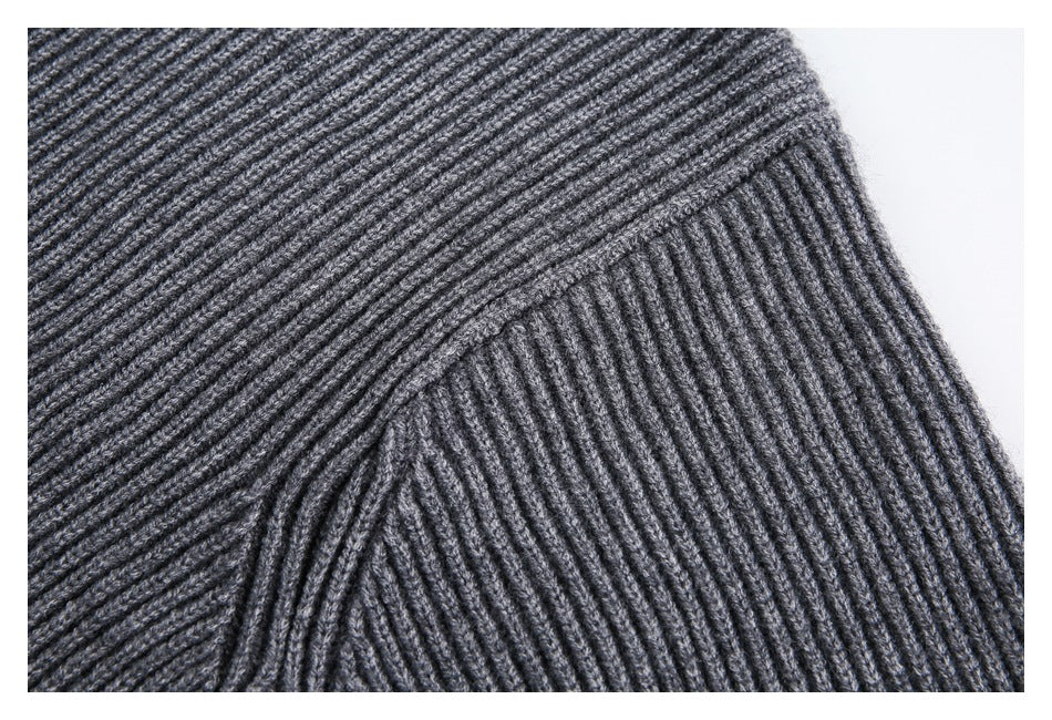 Close-up showing the gray sweater's ribbed knit and shoulder seam.