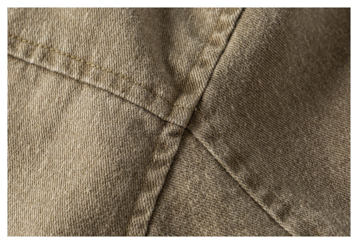 Close-up of intersecting seams and topstitching on tan fabric.