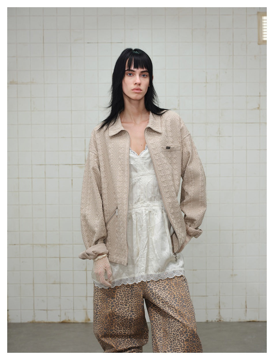 Model wearing the khaki textured zip jacket open over a white lace camisole and leopard print pants