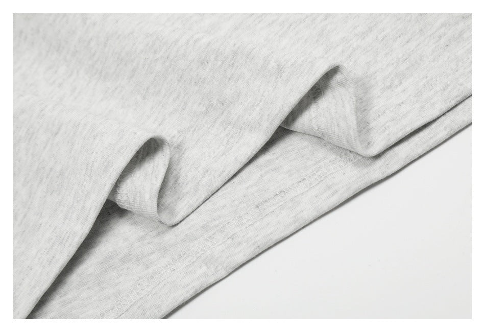 Close-up of light gray heathered fabric with a folded, stitched hem.