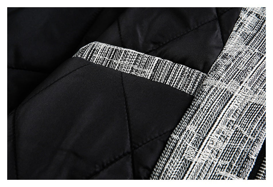 Close-up of black quilted lining beside black-and-white patterned trim.