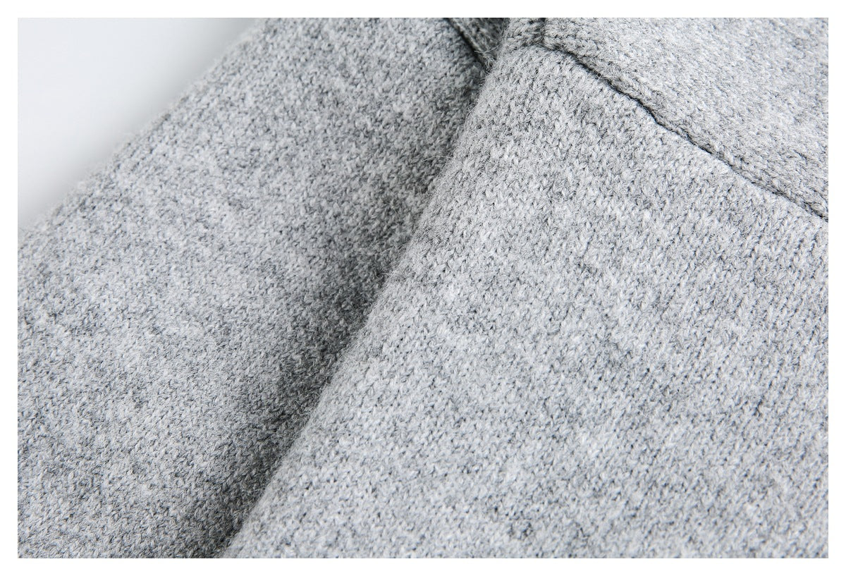 Close-up of a seam joining sections of light gray knit fabric.