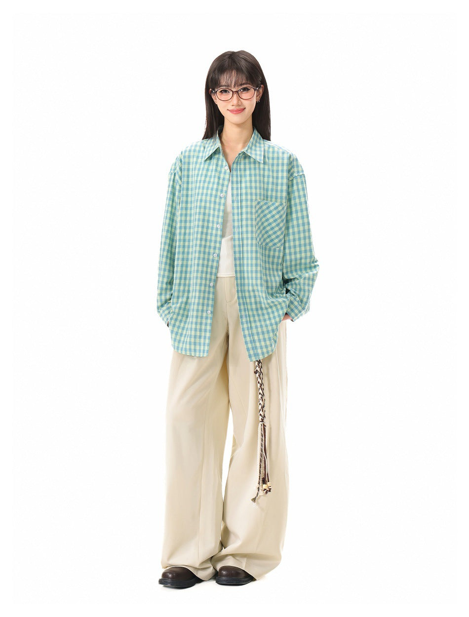 Full-length front view of a model wearing a teal and pale yellow gingham shirt with cream trousers.