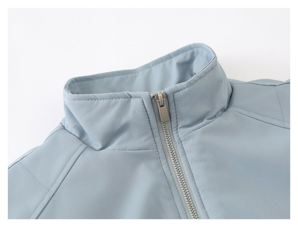 Close-up of the light blue-gray jacket's stand collar and front zipper.