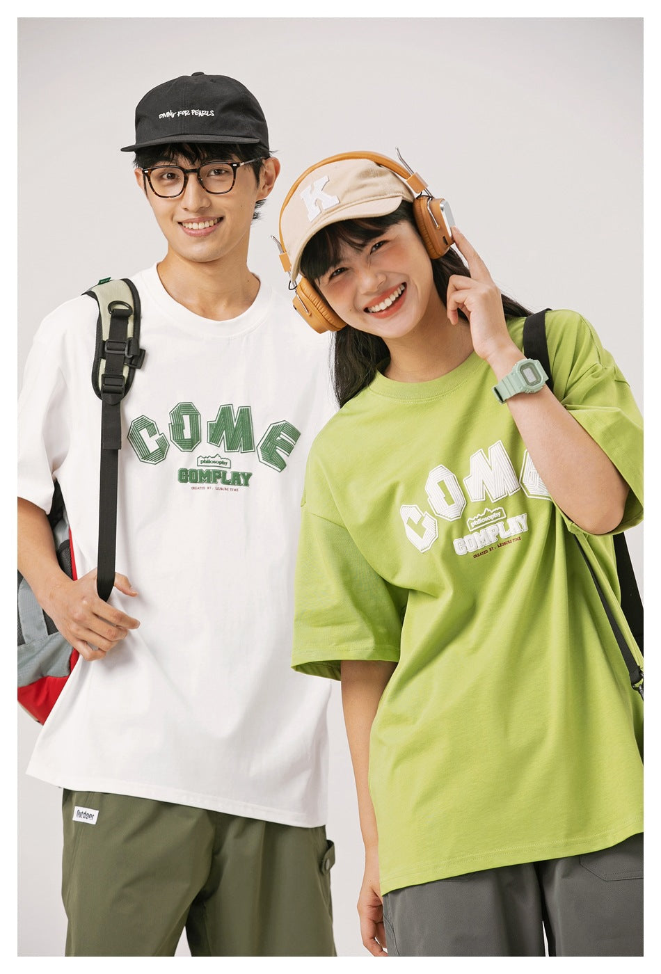 Two models in close view wearing white and lime green oversized graphic T-shirts.