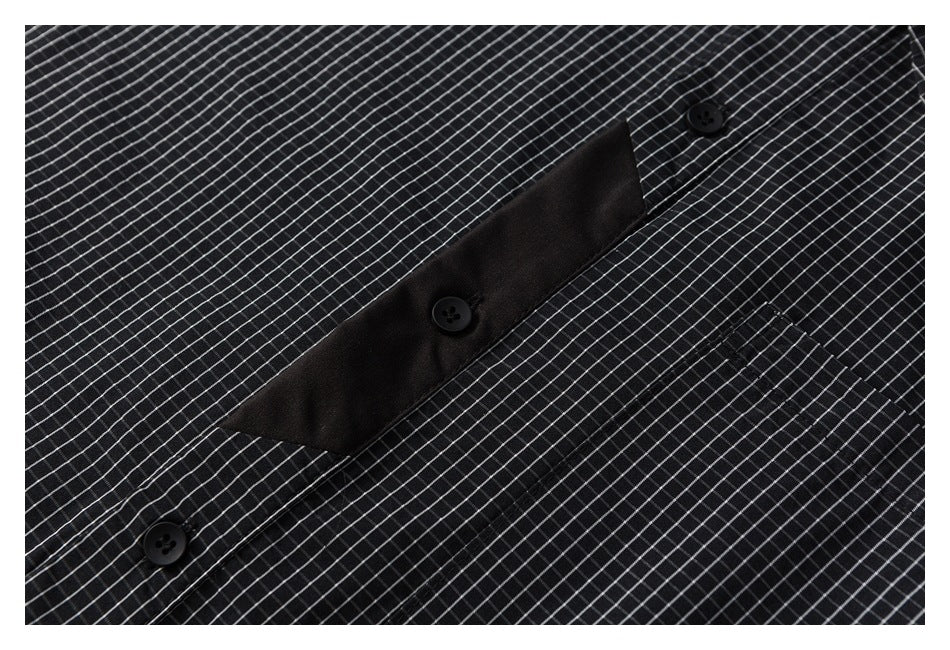 Close-up of the black button placket and fine-grid pattern on the shirt.