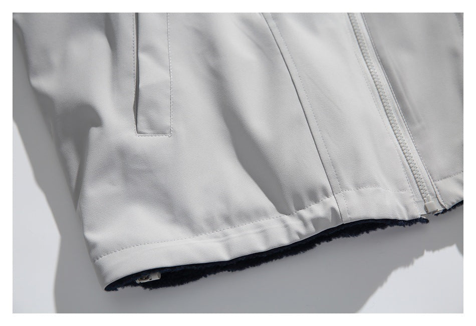 Close-up of the light gray jacket's hem, front zipper, and dark lining visible along the edge.