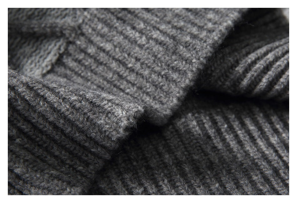 Macro view of the gray sweater's fuzzy knit stitches and ribbed fabric edge.