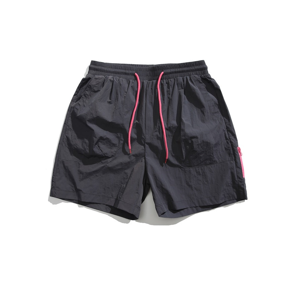 Dark gray drawstring shorts with pink cord, front patch pockets and pink side zipper, flat lay front view