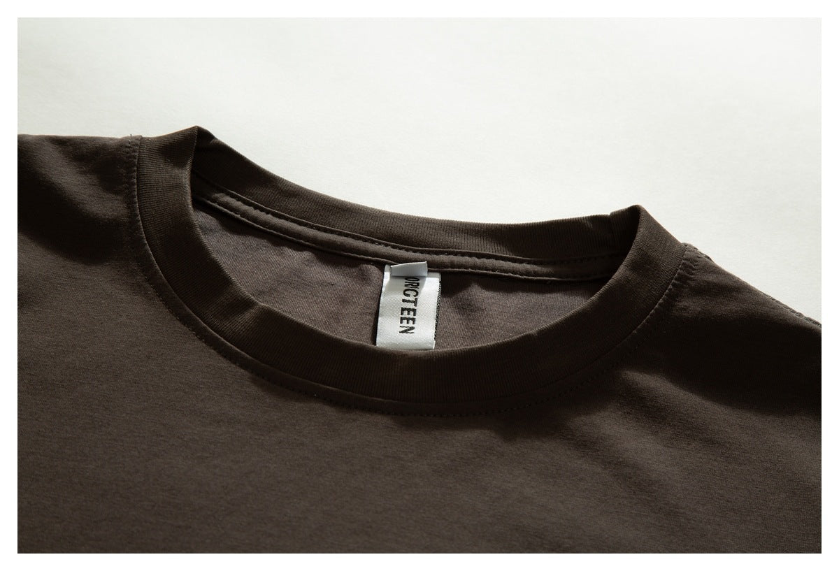 Close-up of the dark brown T-shirt's crew neck, stitching, and inner label.