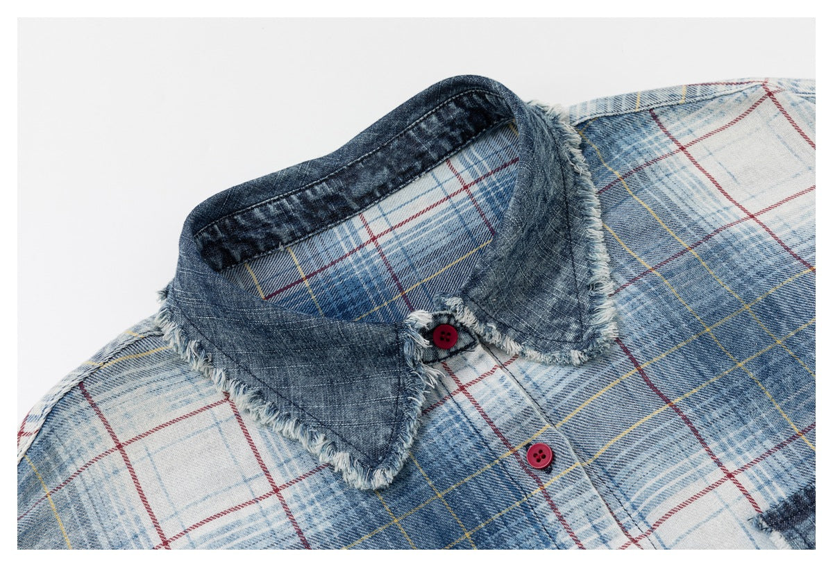 Close-up of the shirt's dark denim collar, frayed trim and red buttons against blue-and-white plaid.
