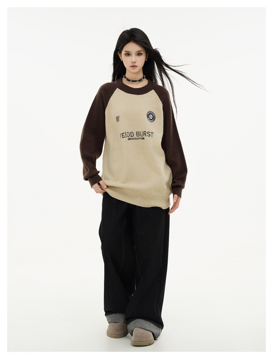 Full-length front view of a model wearing a cream and dark brown raglan sweater with front lettering and emblems.