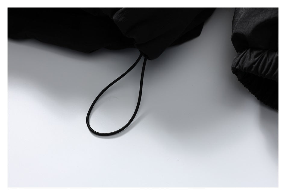 Close-up of a black drawcord loop and gathered cuff on the jacket.