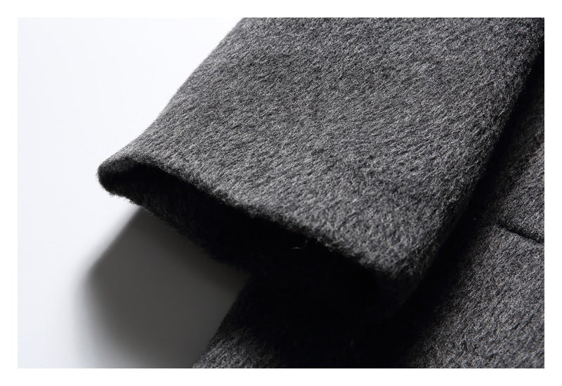 Close-up of the charcoal gray coat sleeve edge and textured surface.